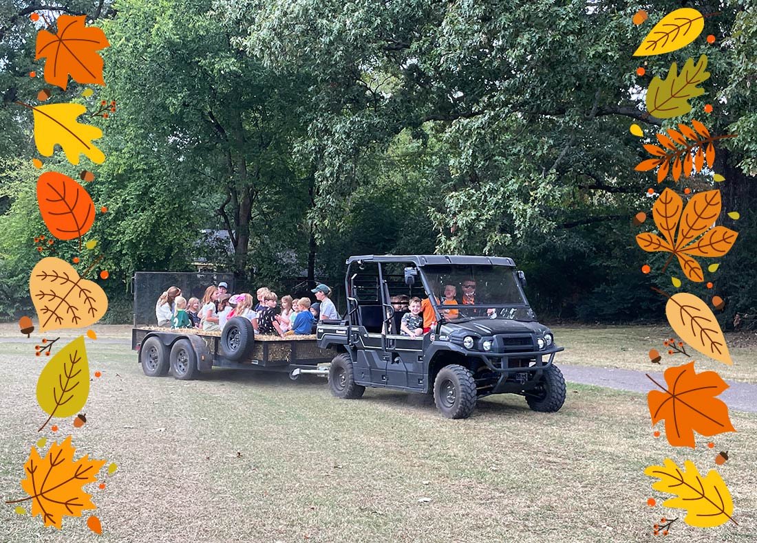 Fall Picnic 2024 Header Image, kids on a hayride with falling leaves as a border