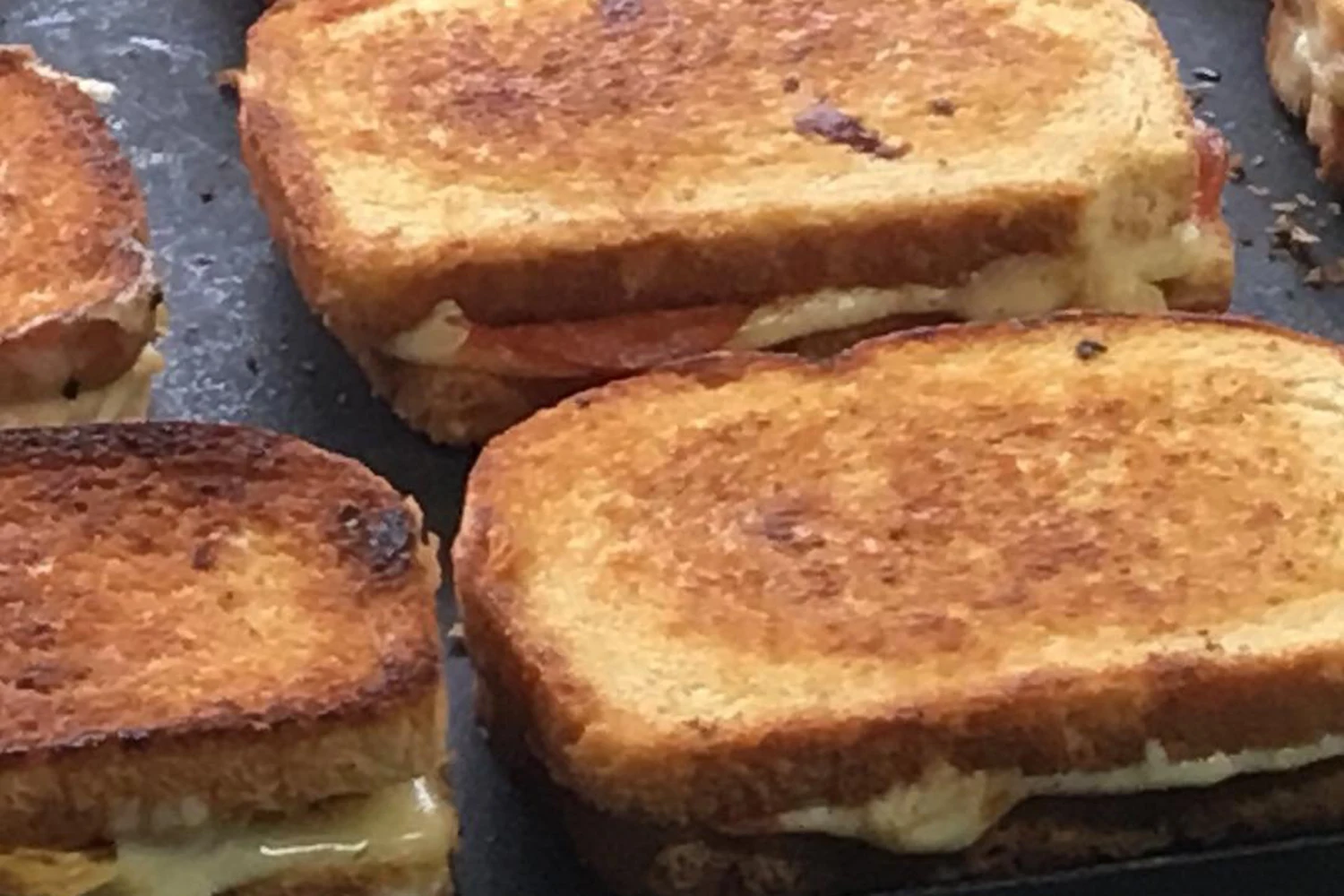Grilled cheese sandwiches cooking on a stovetop