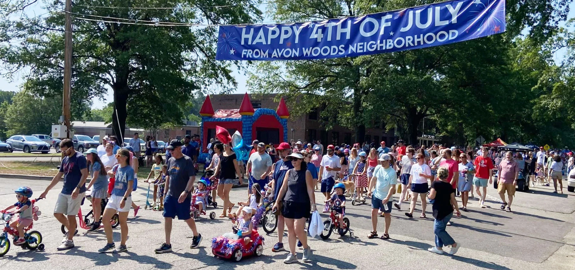 Start of the 2024 Avon Woods Fourth of July Parade with banner overhead
