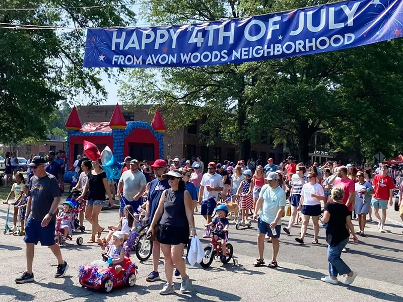 Start of the 2024 Avon Woods Fourth of July Parade with banner overhead